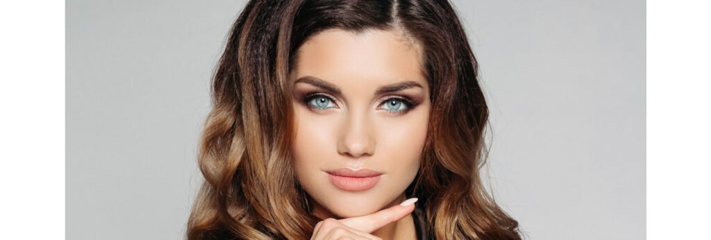 mulher morena com rosto harmonizado naturalmente apoia o rosto sobre o dedo em fundo neutro